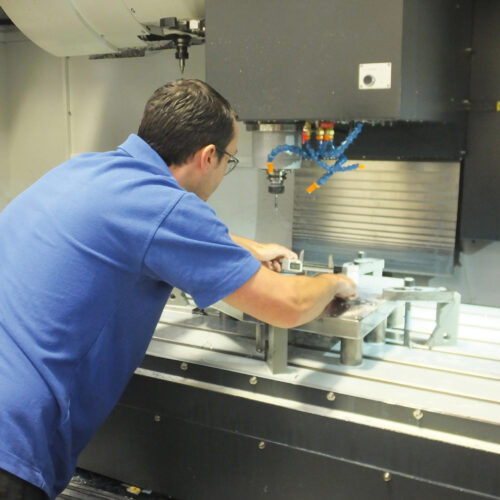 Hyfore employee setting up fixtures in a CNC milling machine